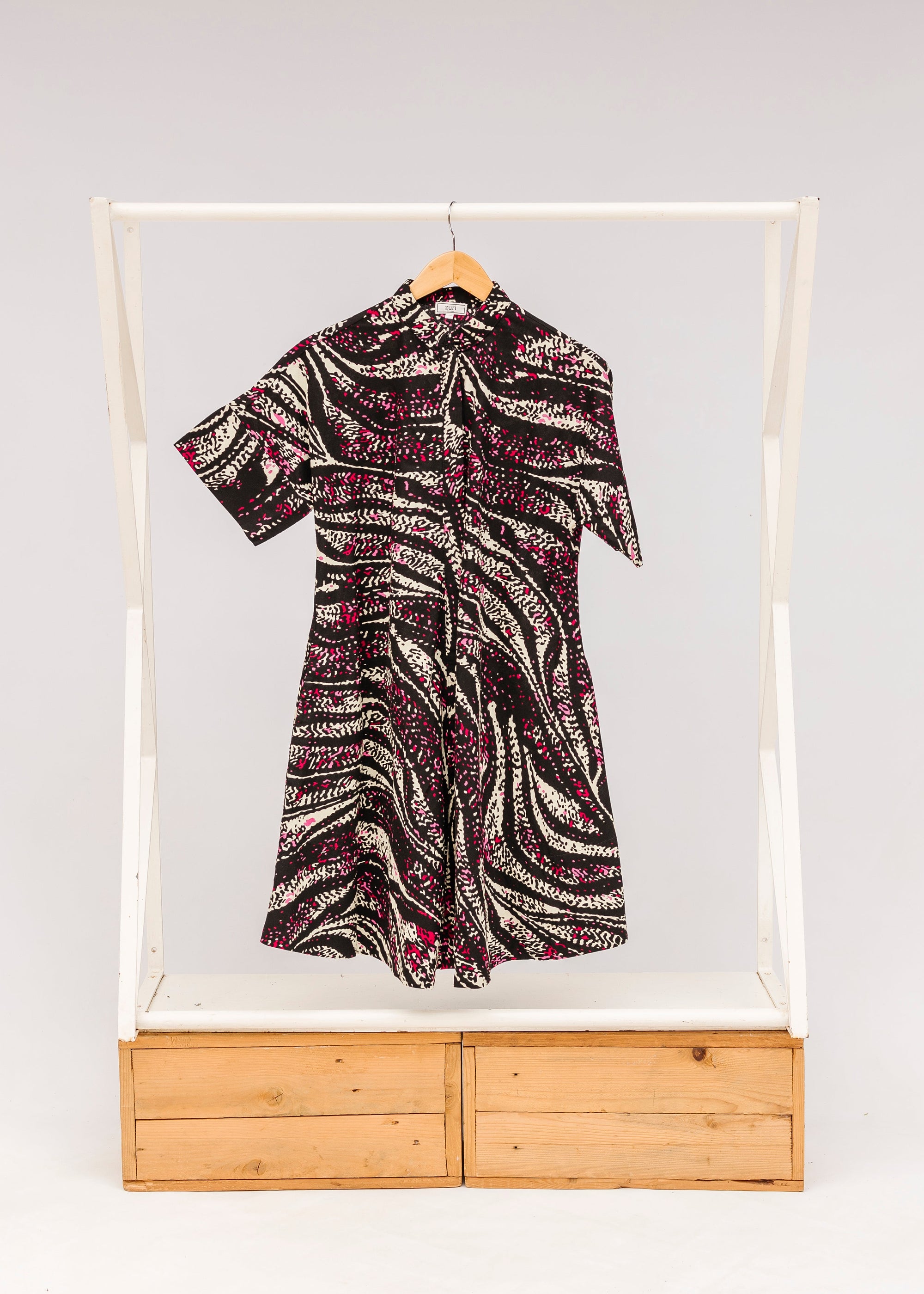 Display of pink, black and white glitter print dress.