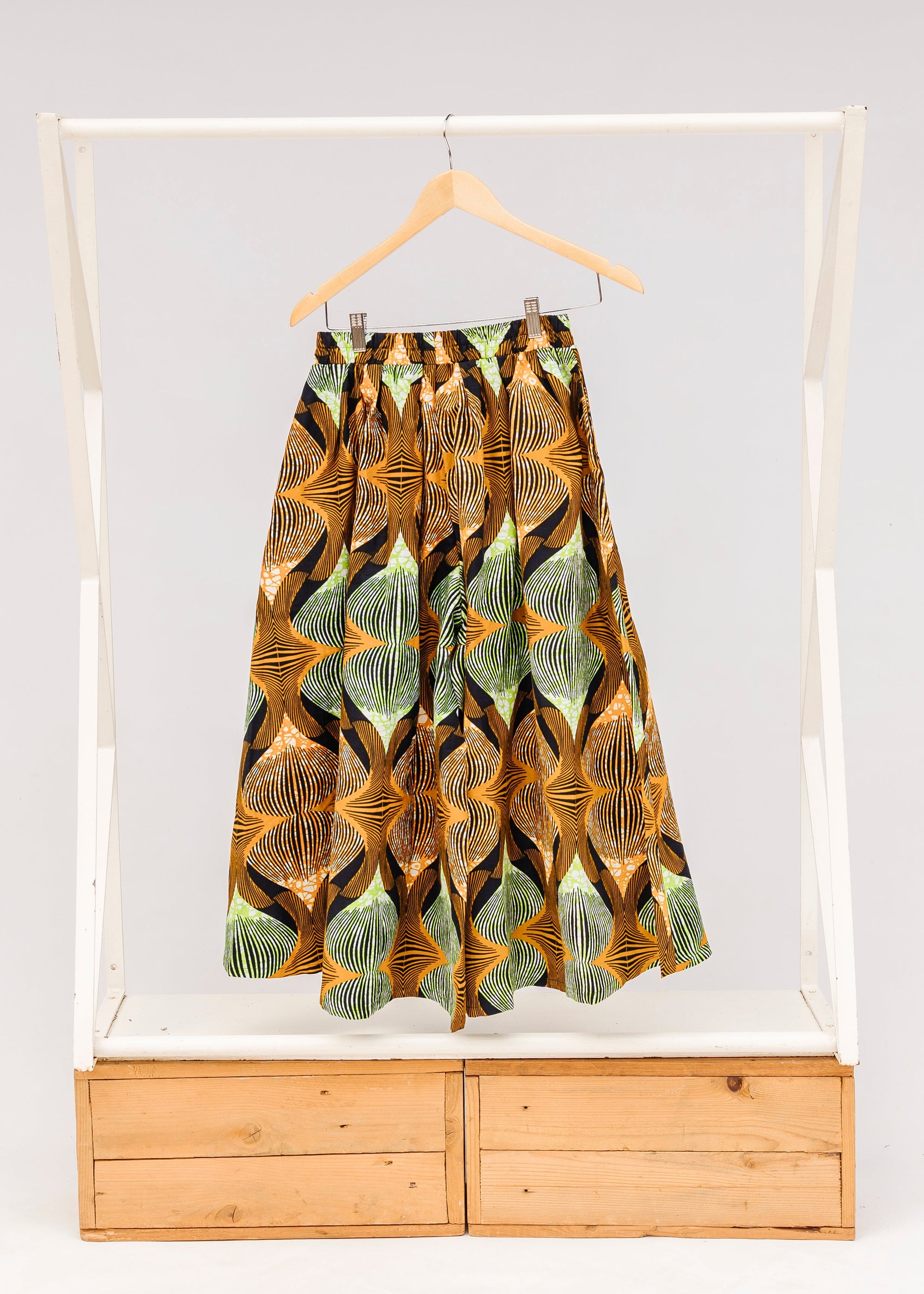 Display of orange and green geometric print pants.