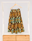 Display of orange and green geometric print pants.