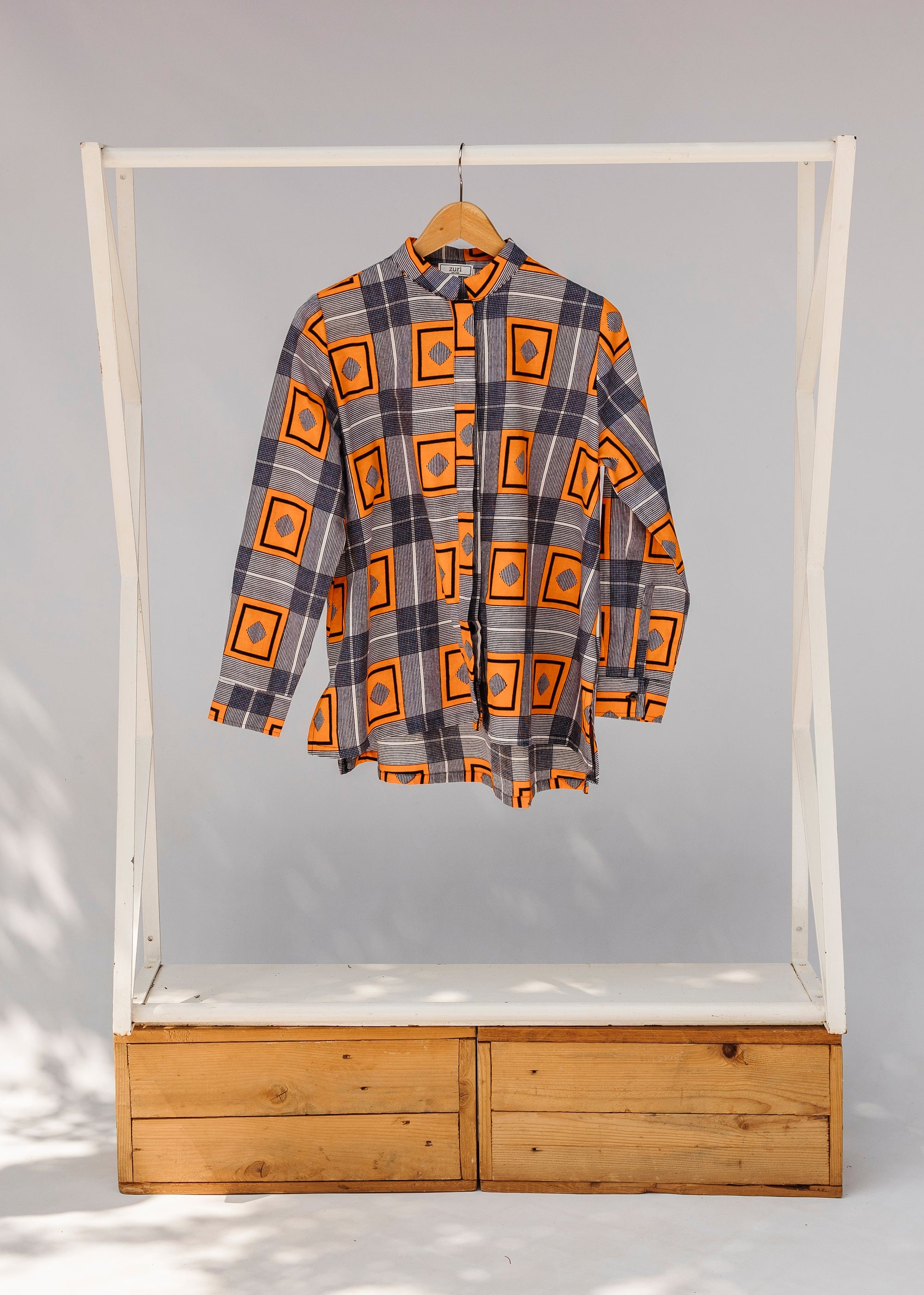 Display of orange, navy and white geometric print shirt.