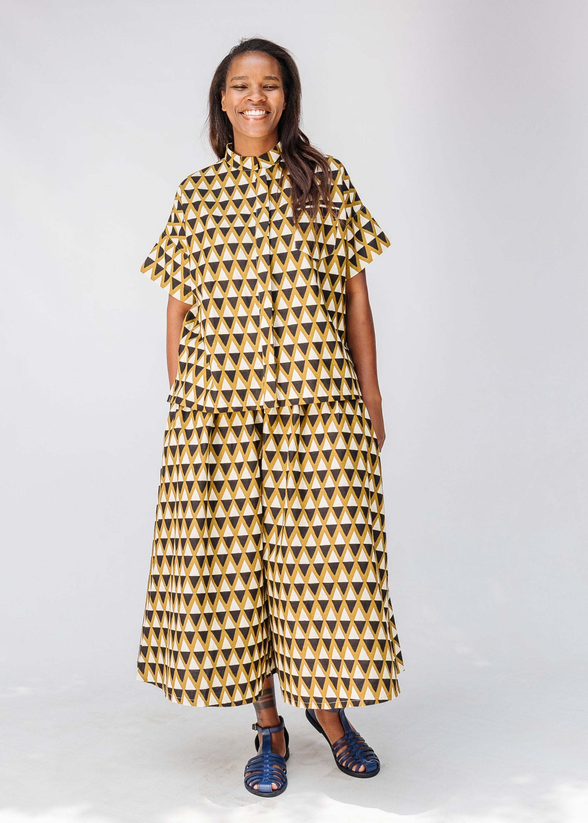 Model wearing mustard and black triangle print pants and shirt.