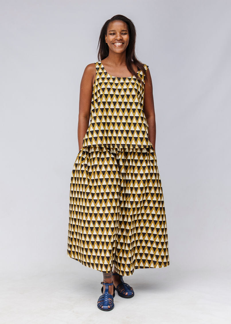 Model wearing mustard and black triangle print pants and tank.