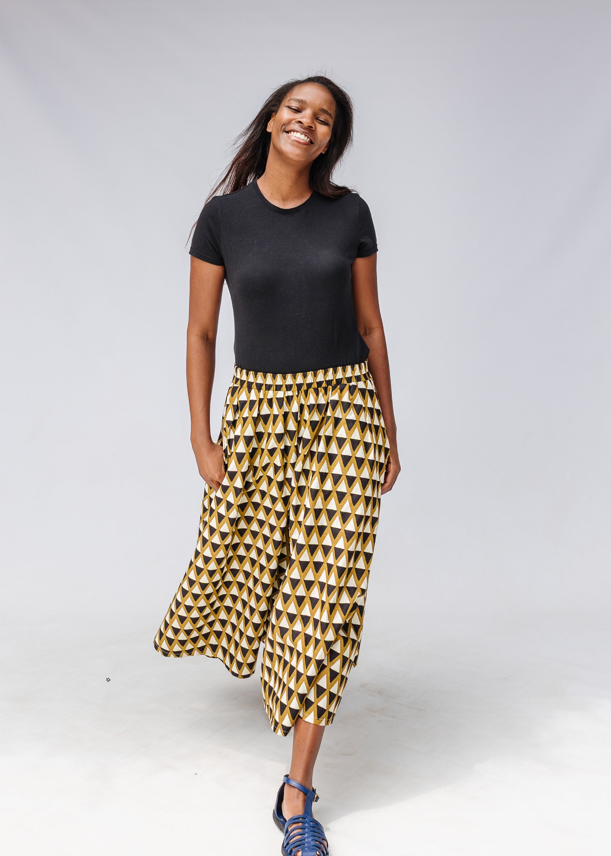 Model wearing mustard and black triangle print pants.