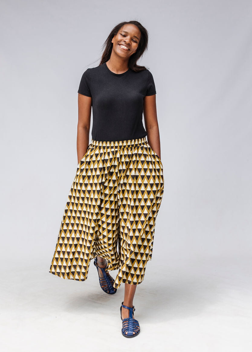 Model wearing mustard and black triangle print pants.
