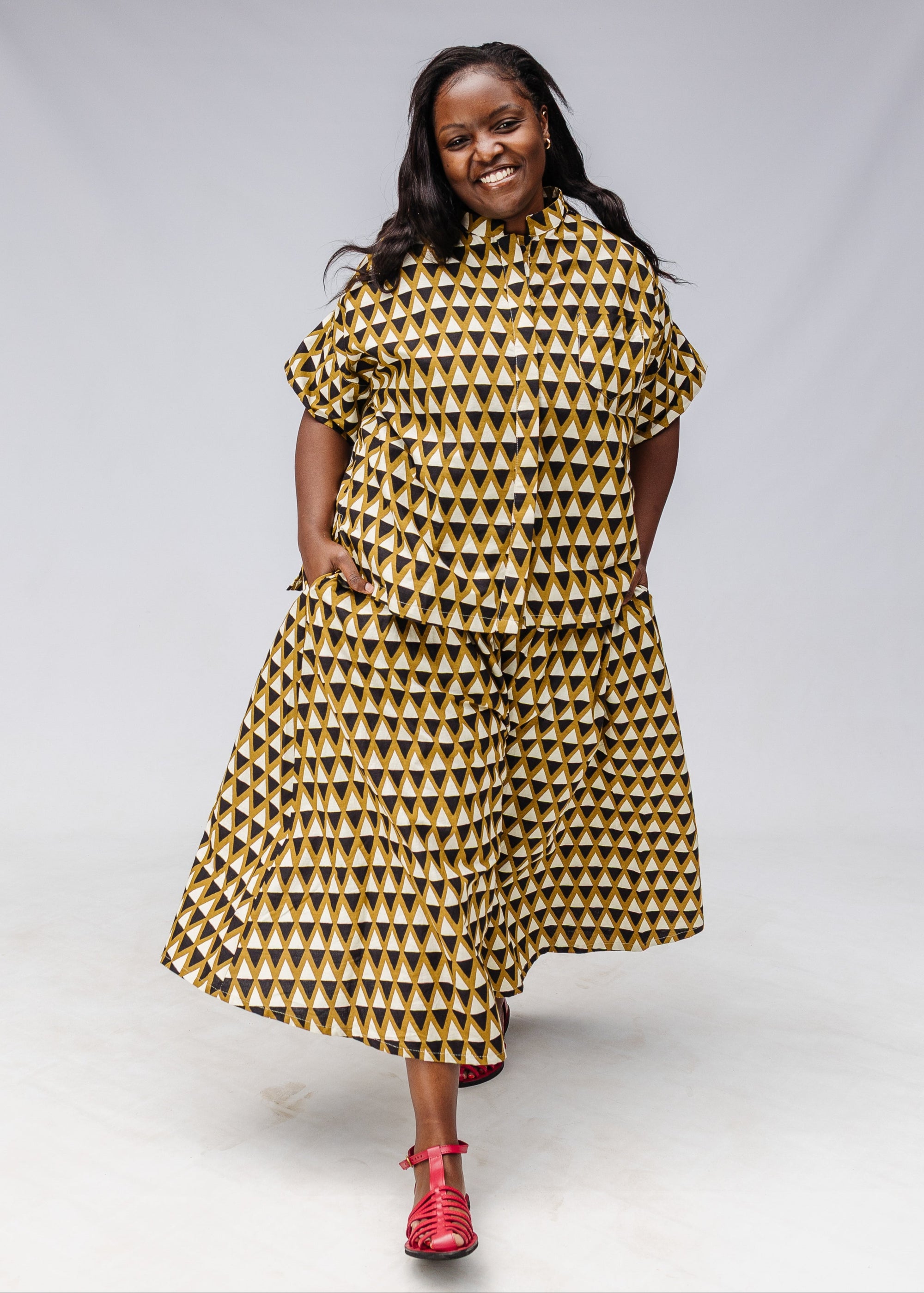 Model wearing mustard and black triangle print pants and shirt.