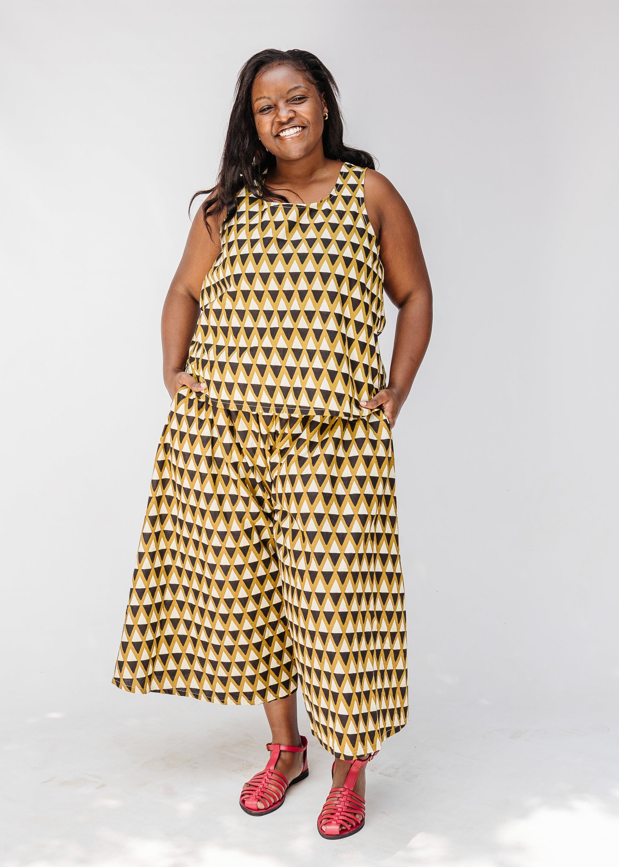 Model wearing mustard and black triangle print pants and tank.