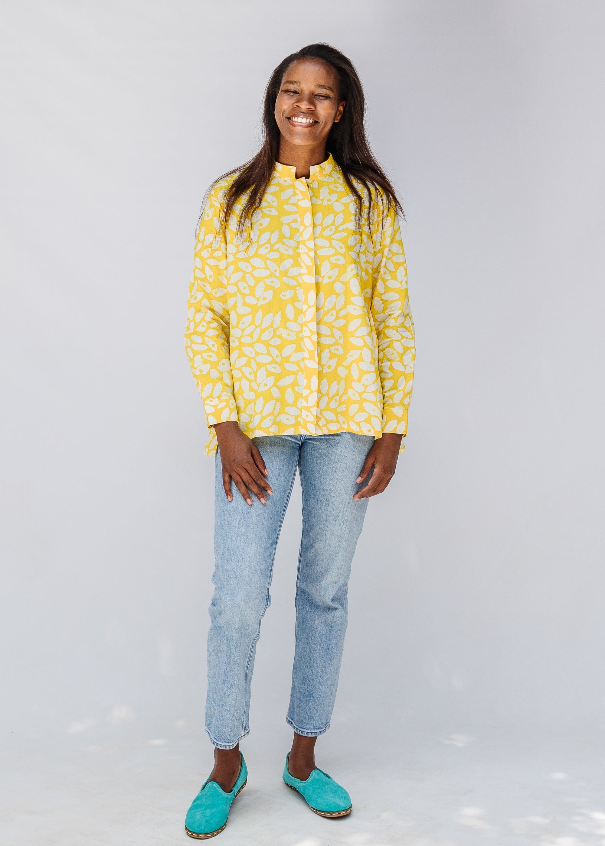 Model wearing yellow long sleeve shirt with white leaf print.