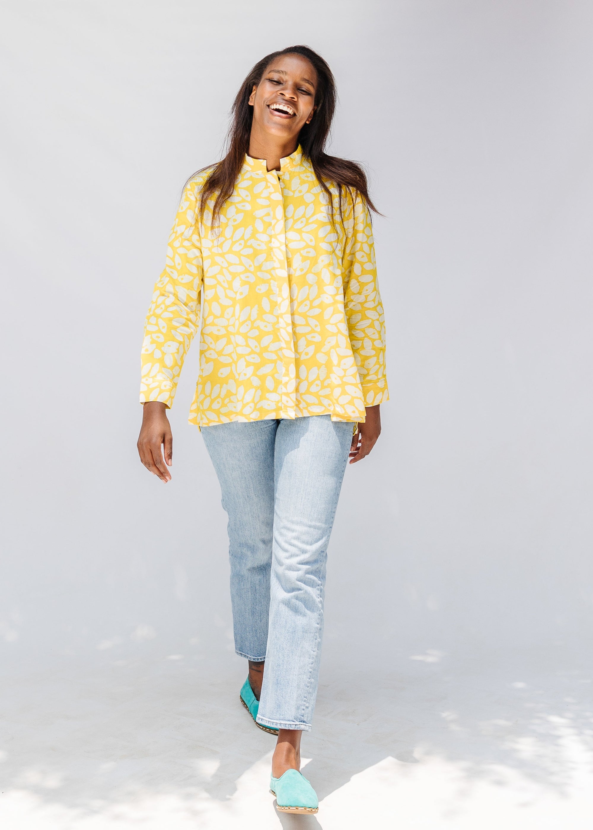 Model wearing yellow long sleeve shirt with white leaf print.