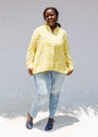 Model wearing yellow long sleeve shirt with white leaf print.