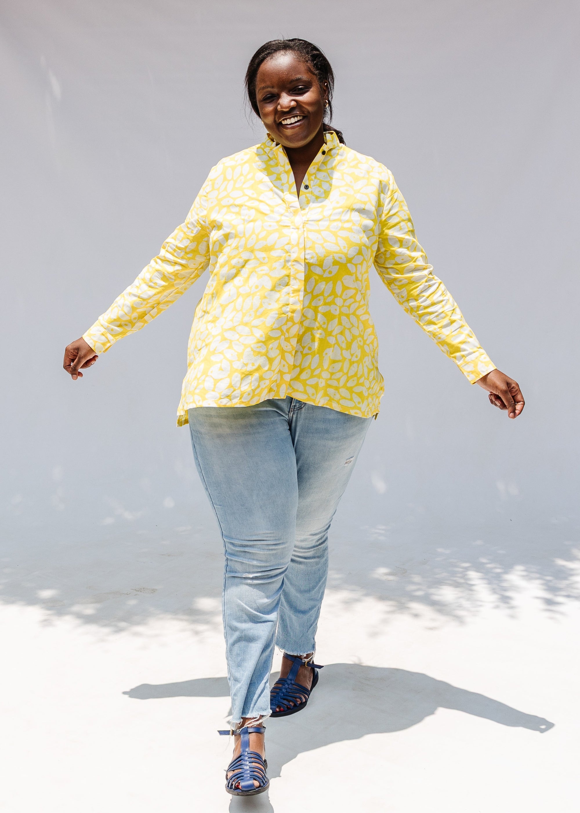 Model wearing yellow long sleeve shirt with white leaf print.