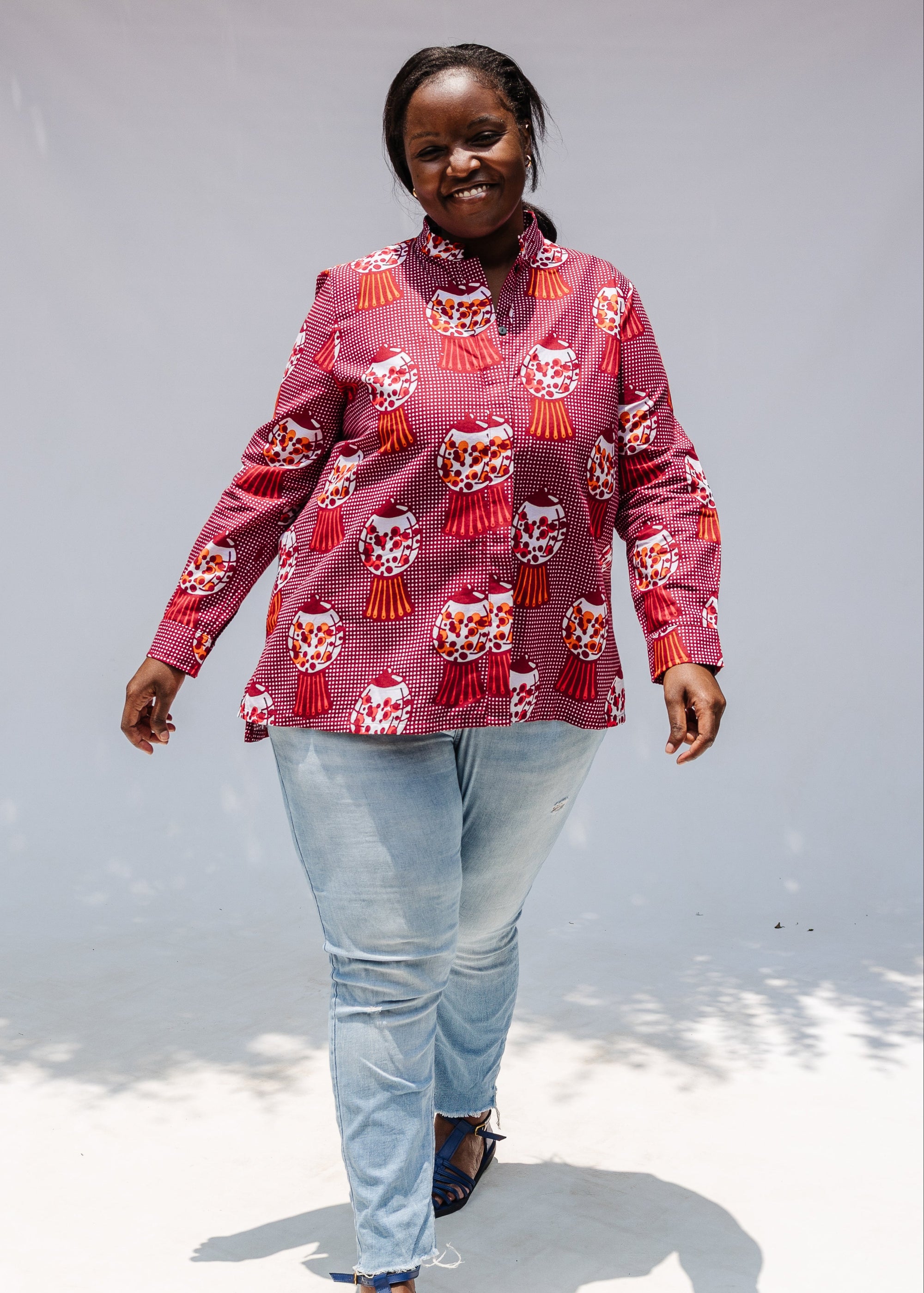 Model wearing red shirt with orange and white gumball print.