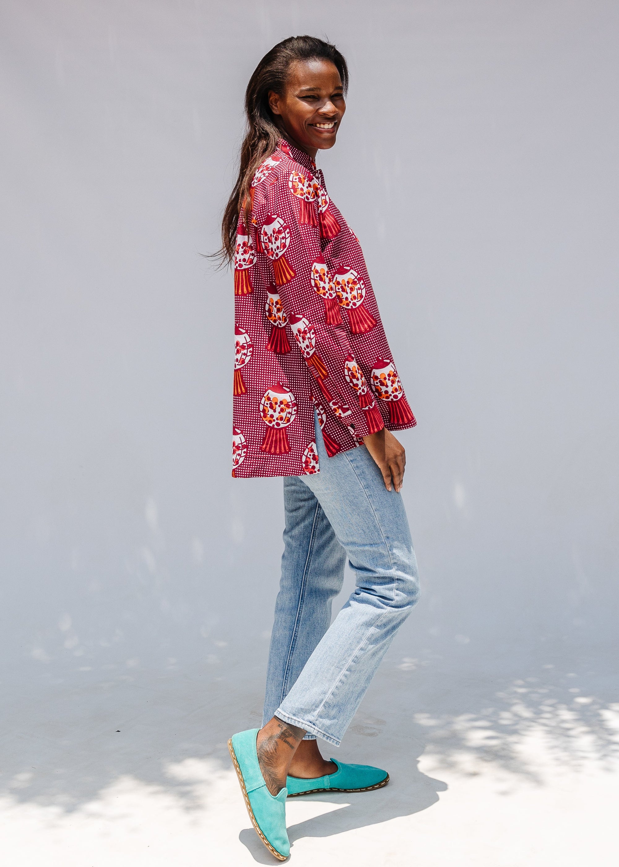 Model wearing red shirt with orange and white gumball print.