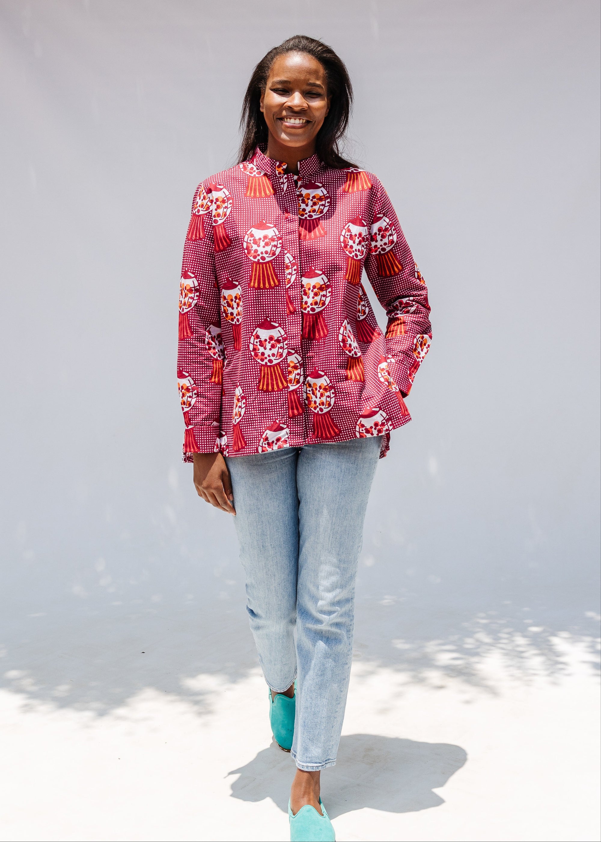 Model wearing red shirt with orange and white gumball print.