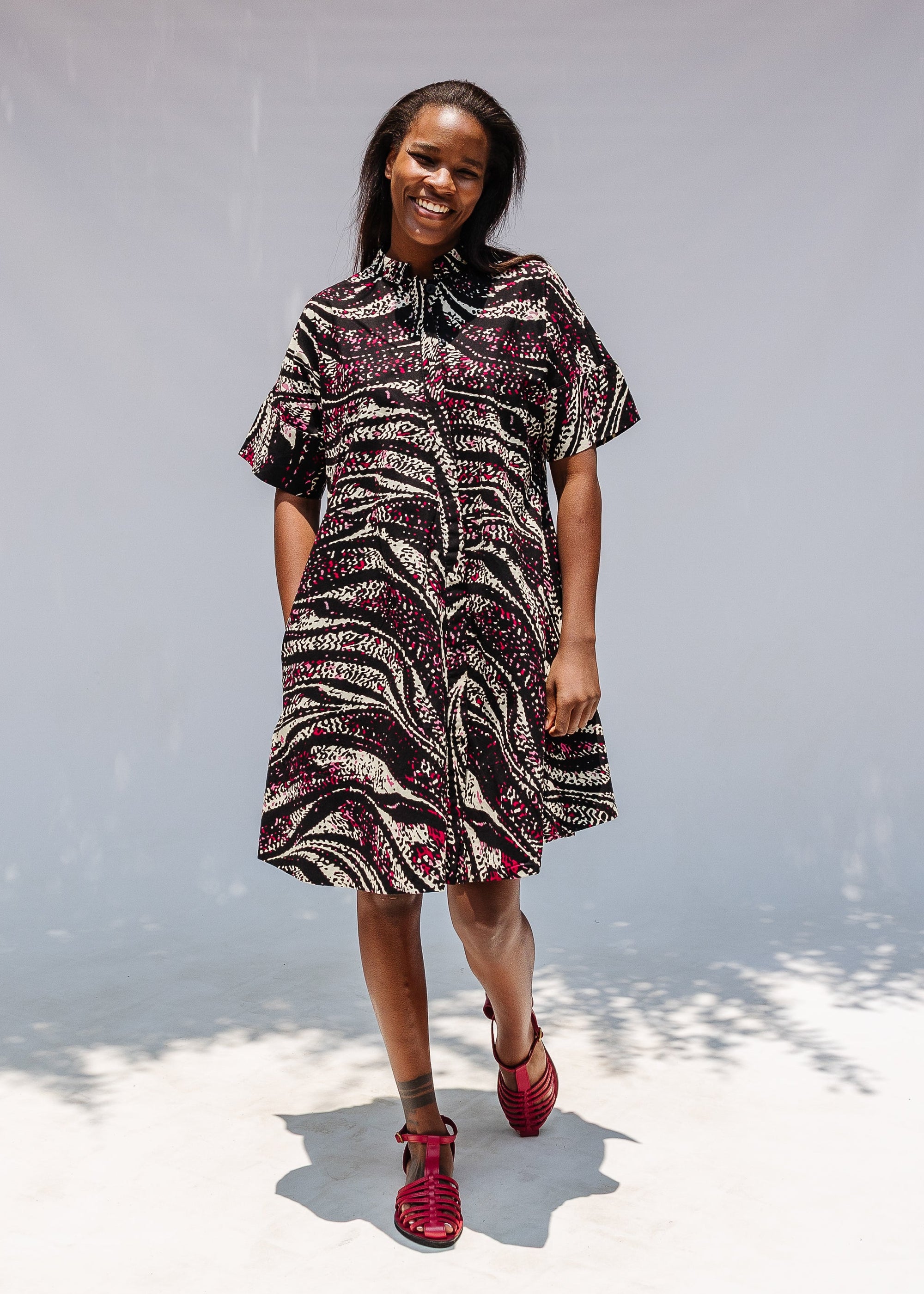 Model wearing pink, black and white glitter print dress