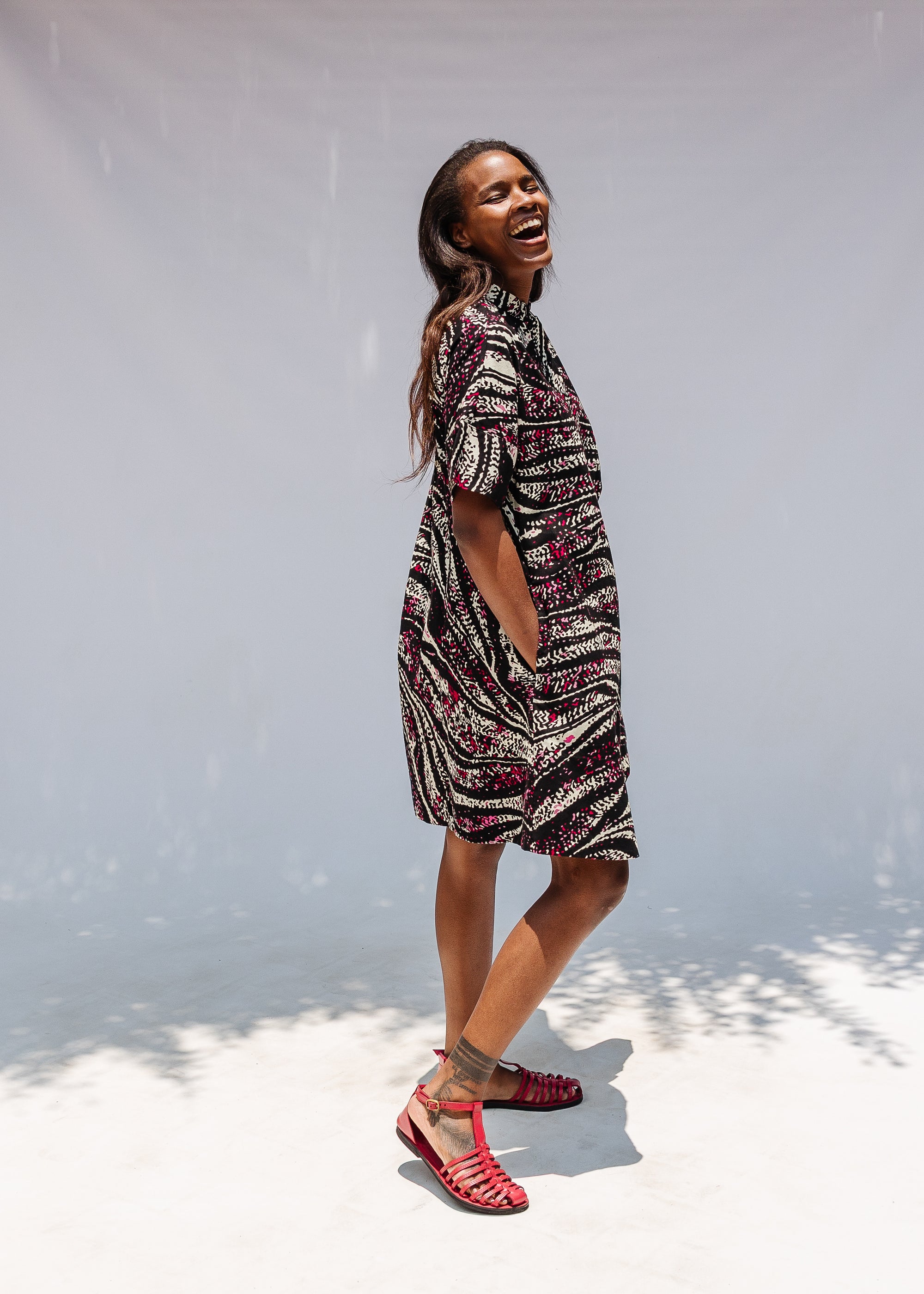 Model wearing pink, black and white glitter print dress