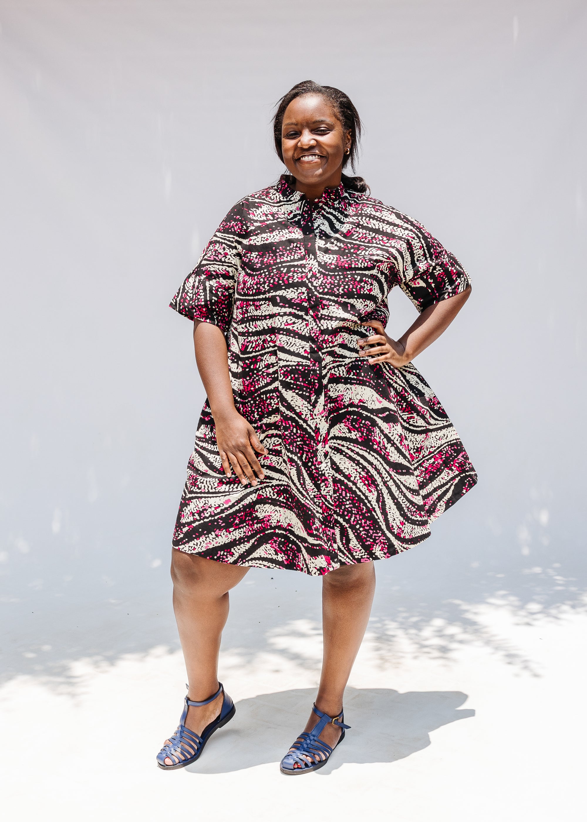 Model wearing pink, black and white glitter print dress