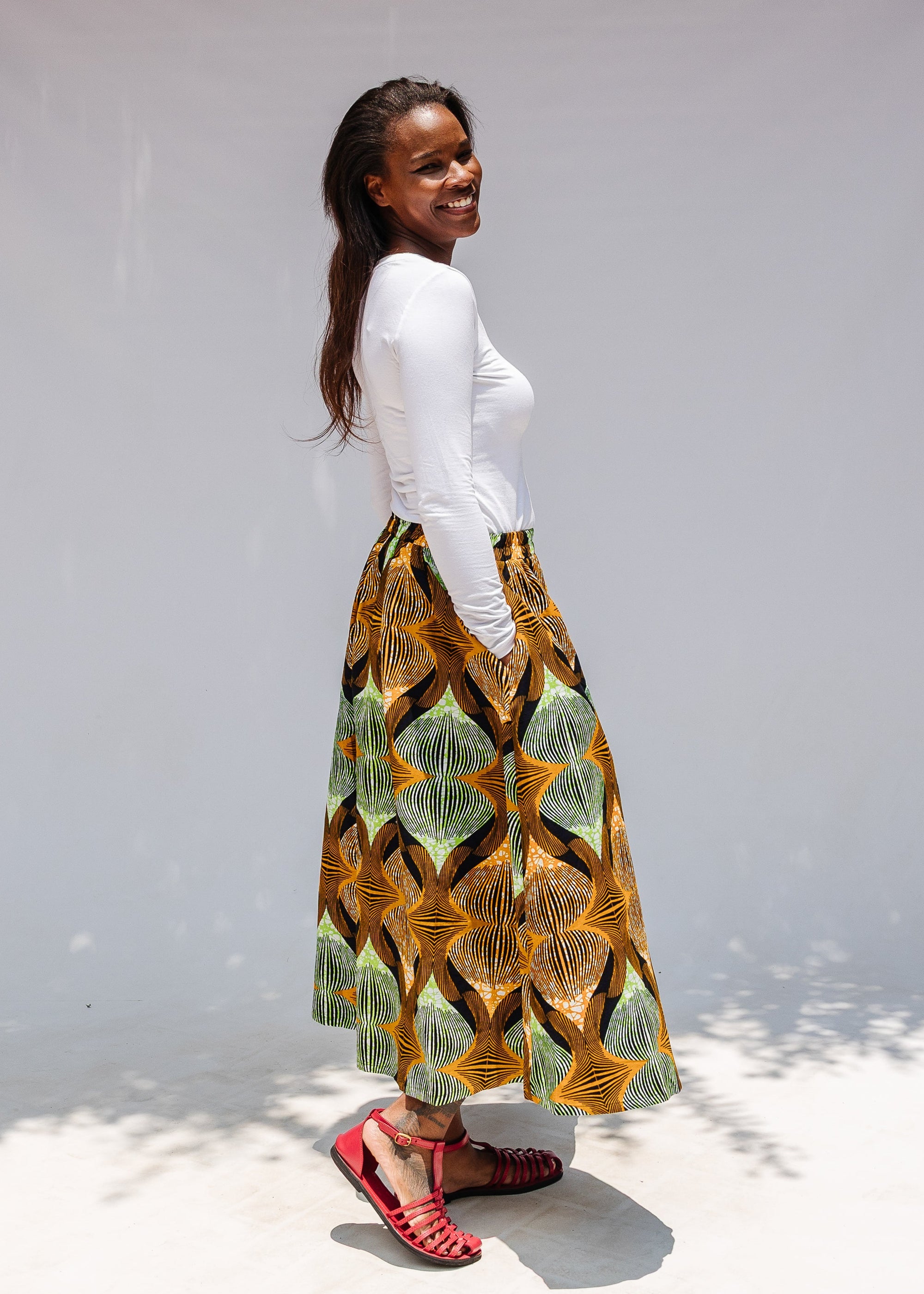 Model wearing orange and green geometric print pants.