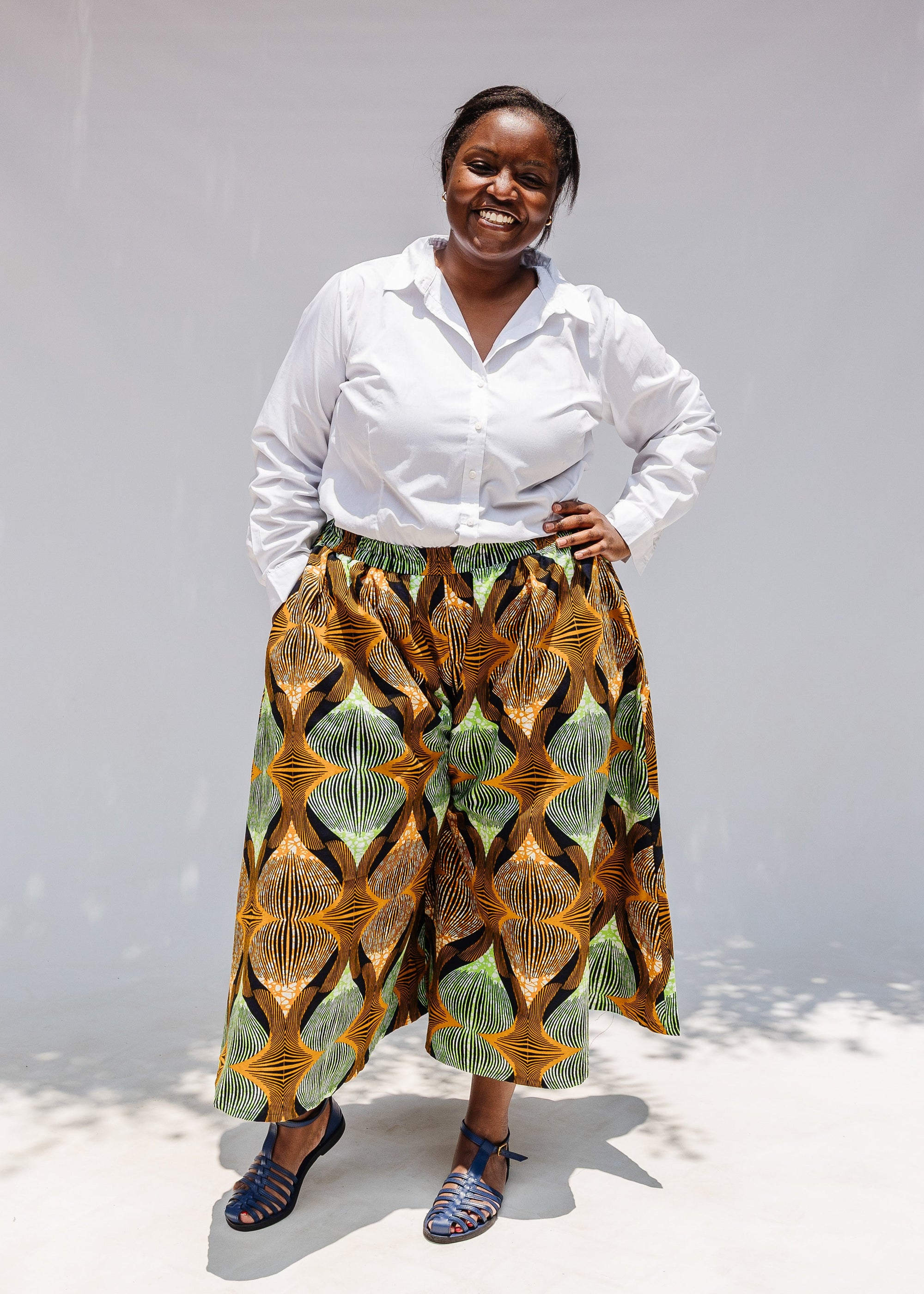 Model wearing orange and green geometric print pants.