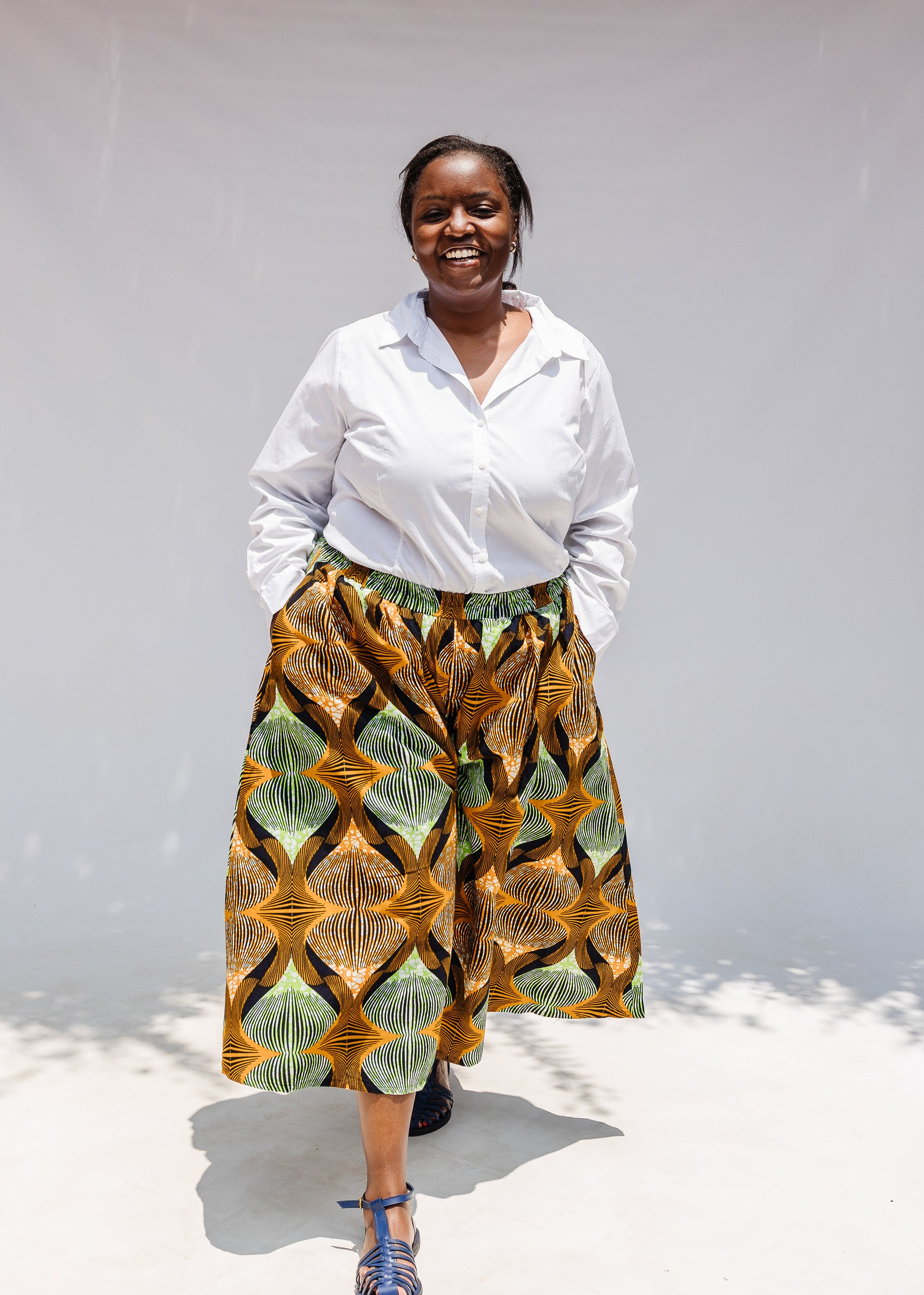 Model wearing orange and green geometric print pants.