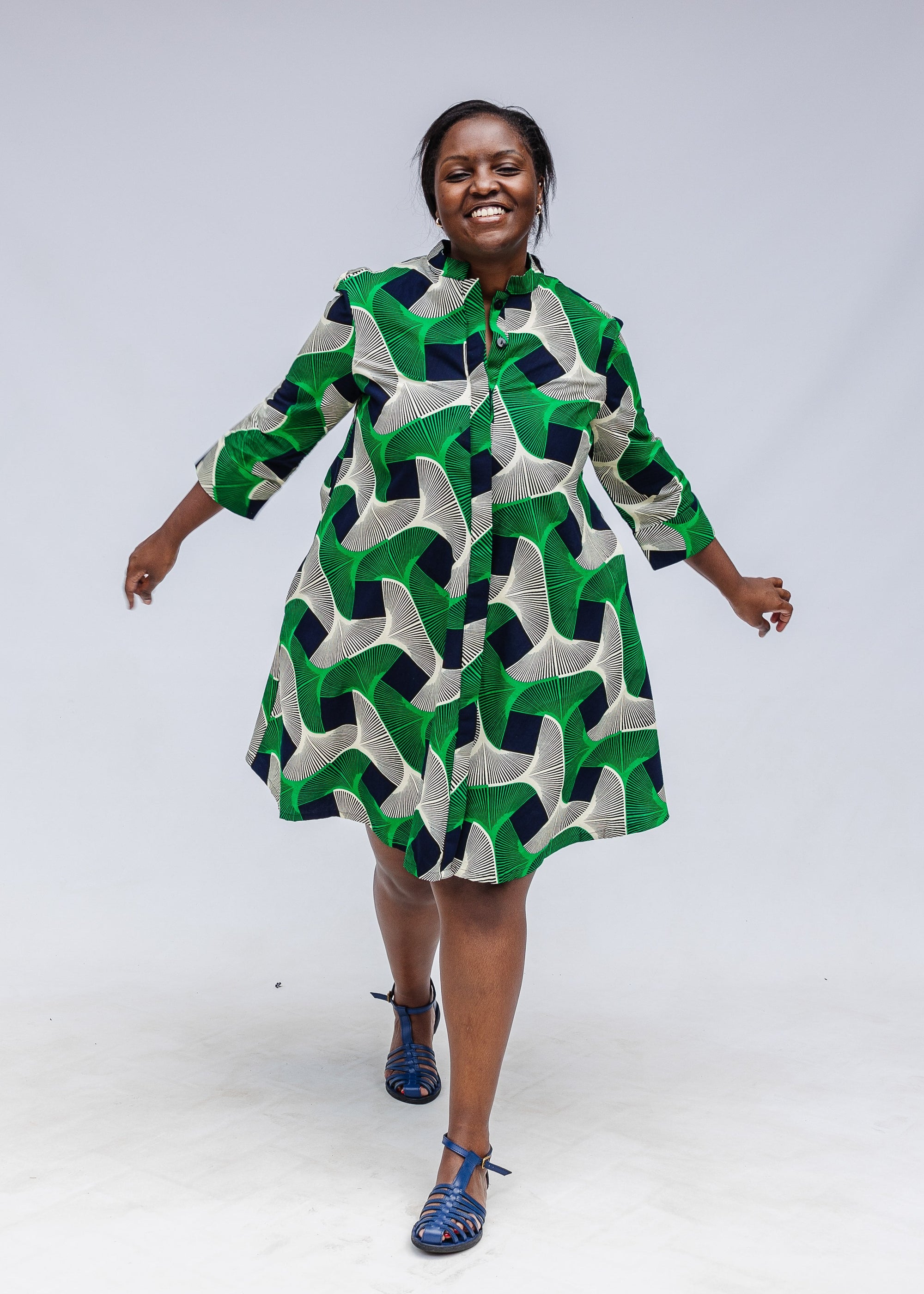 Model wearing green, black and white abstract print dress. 