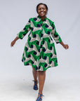 Model wearing green, black and white abstract print dress. 