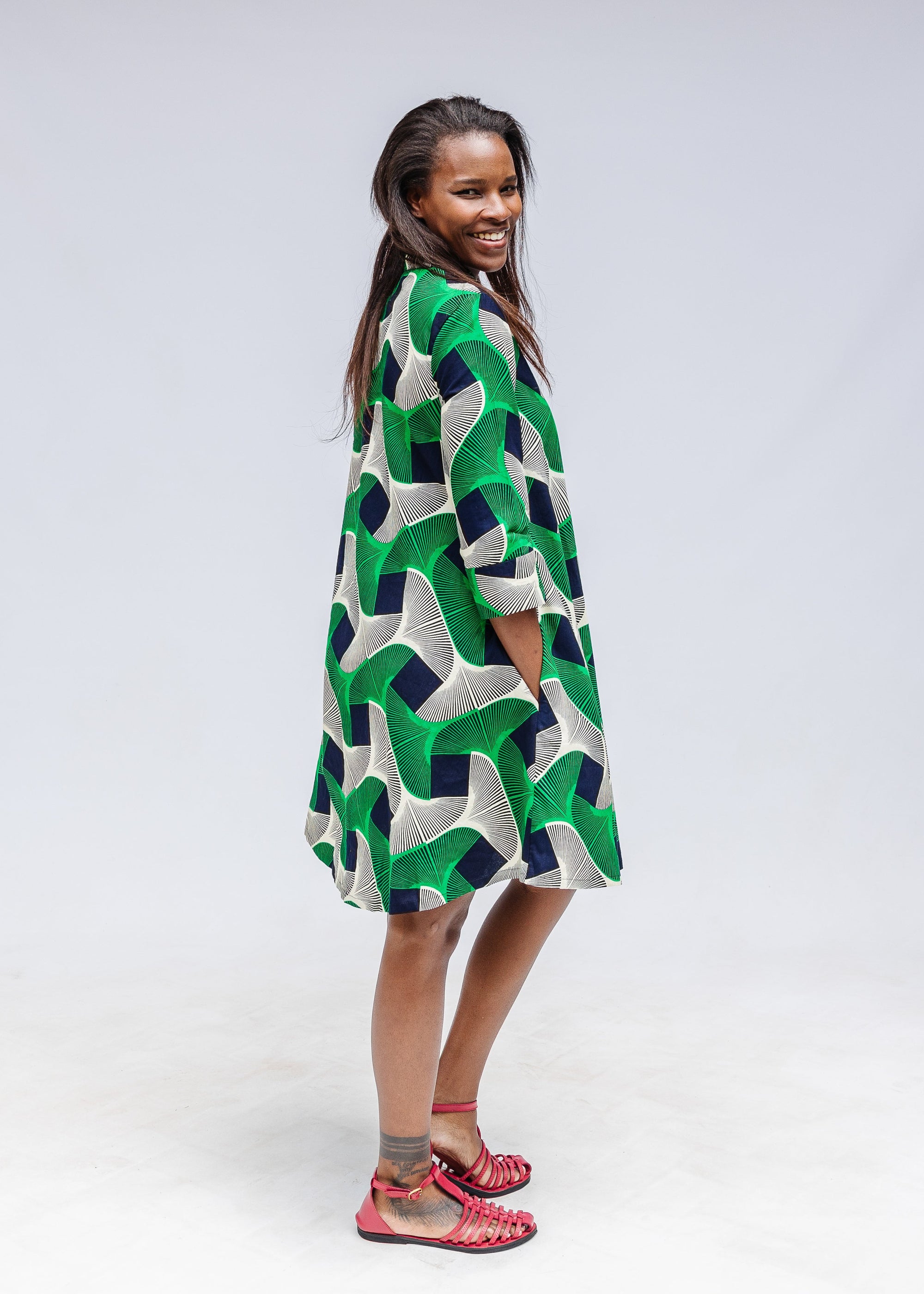 Model wearing green, black and white abstract print dress. 