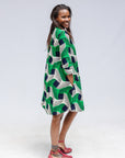 Model wearing green, black and white abstract print dress. 