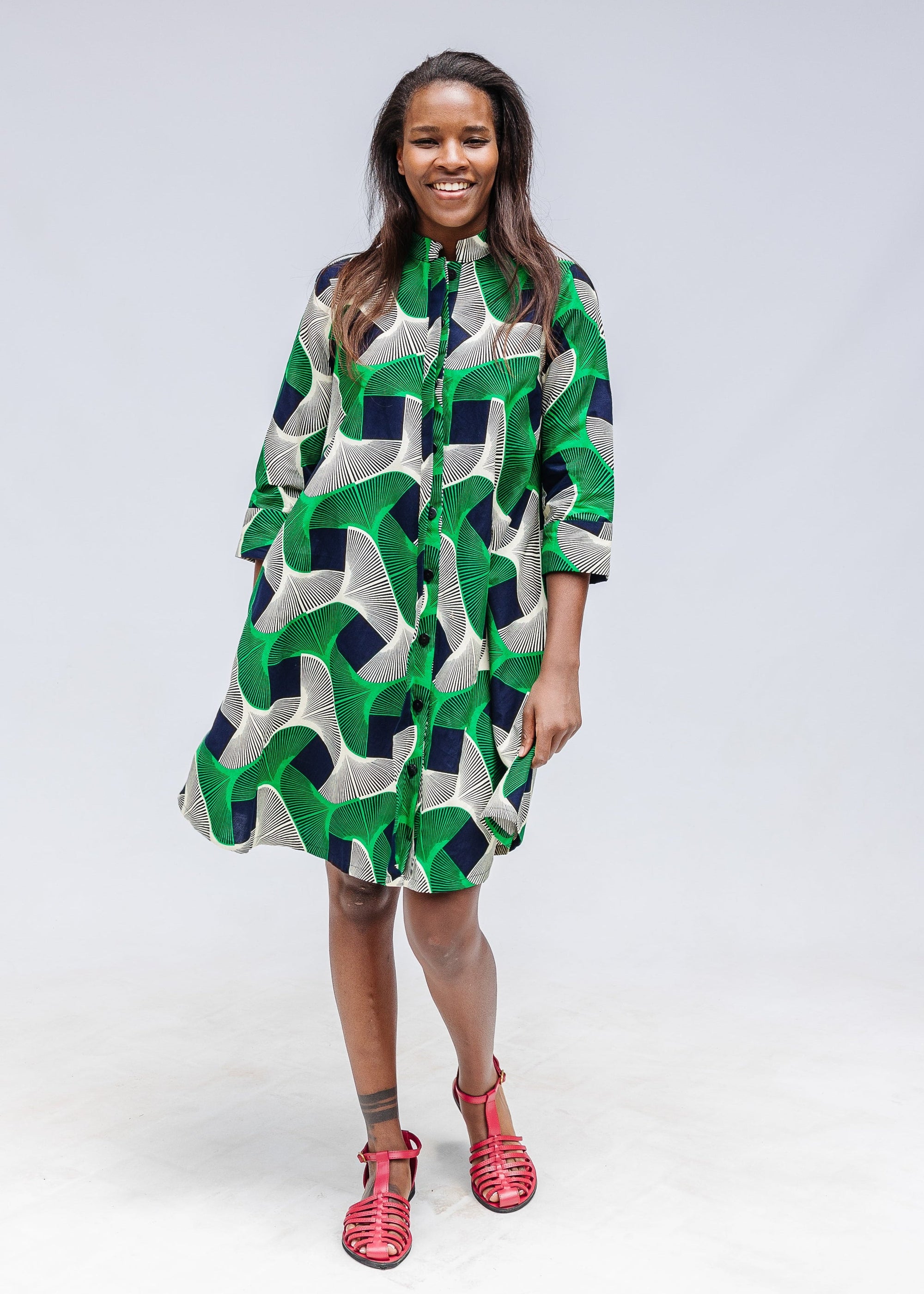 Model wearing green, black and white abstract print dress. 