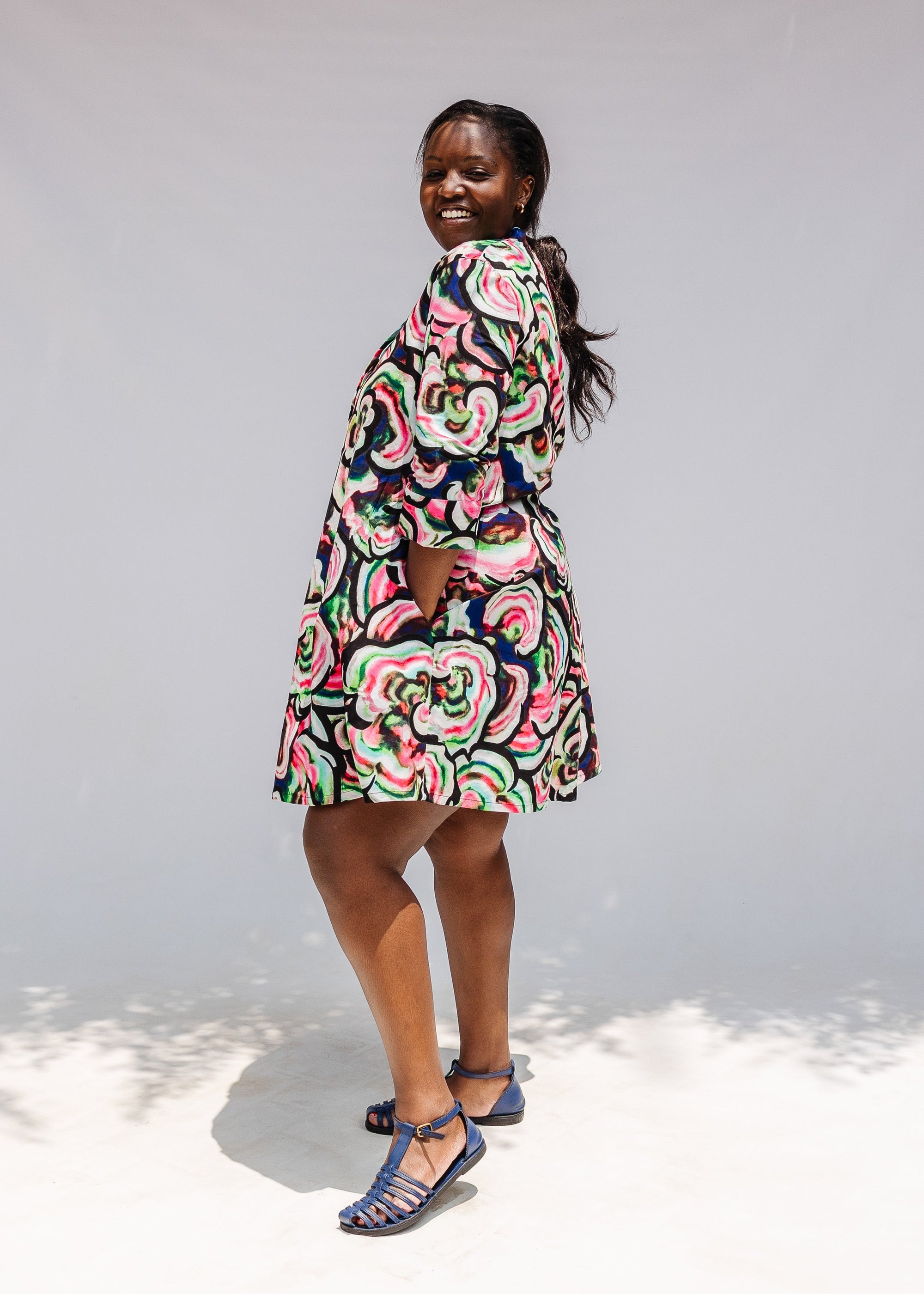 Model wearing colorful abstract print dress.