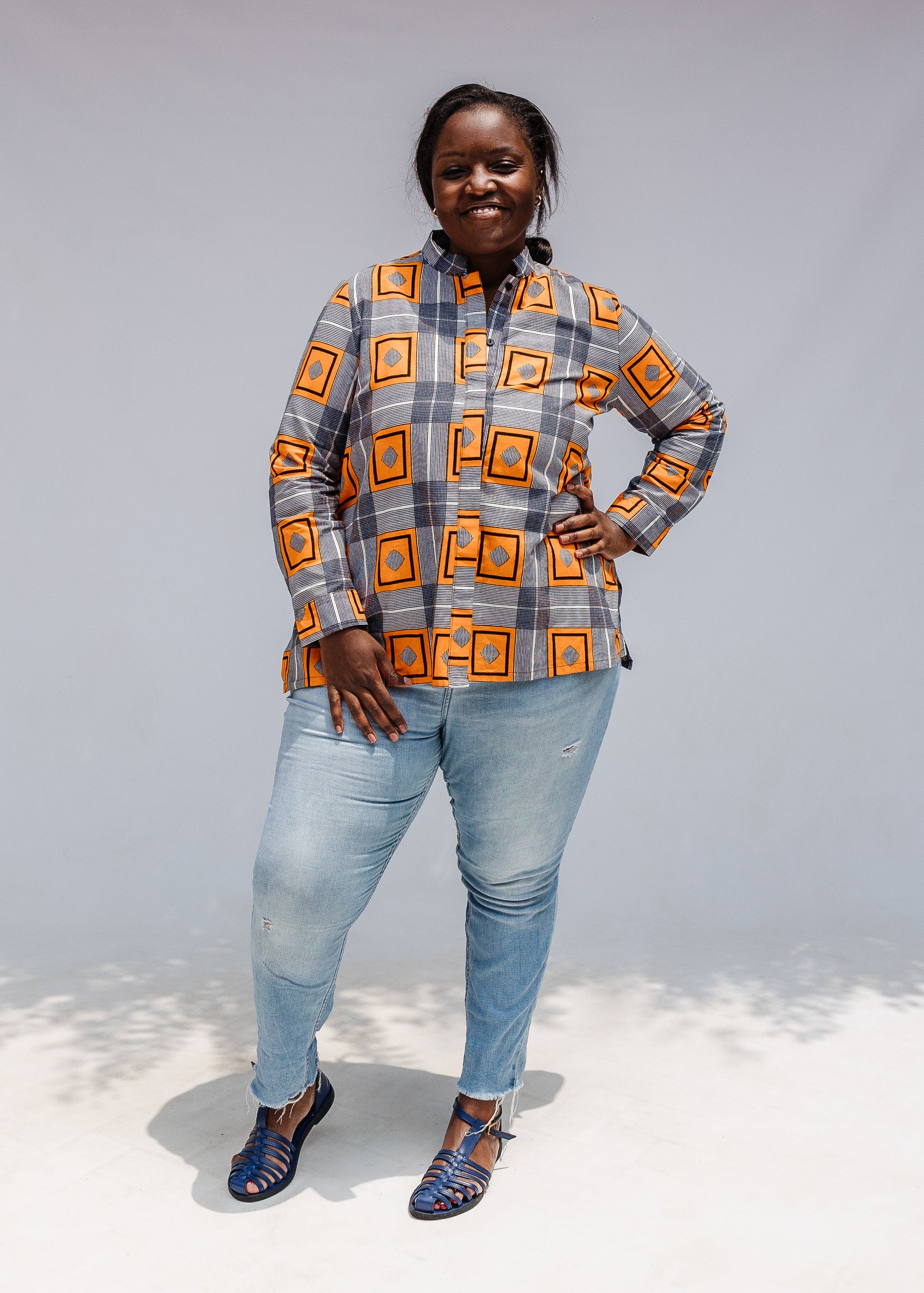 Model wearing orange, navy and white geometric print shirt.