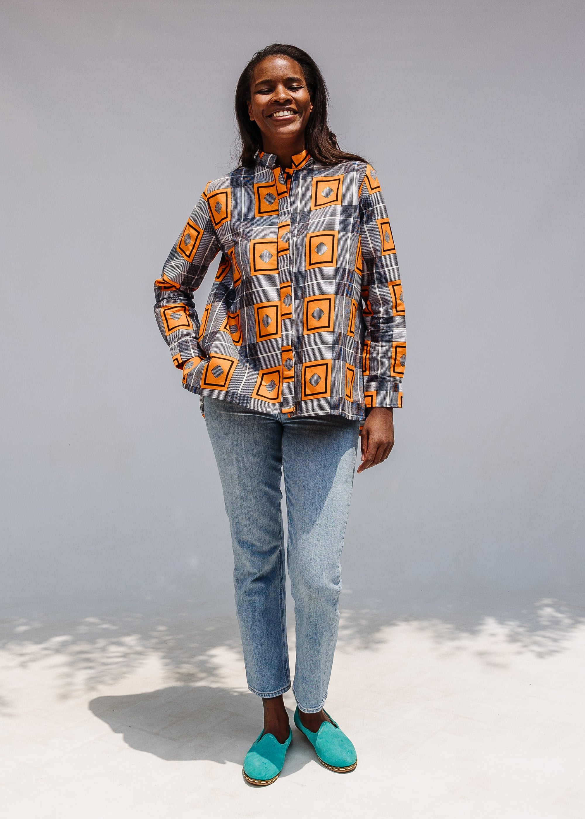 Model wearing orange, navy and white geometric print shirt.