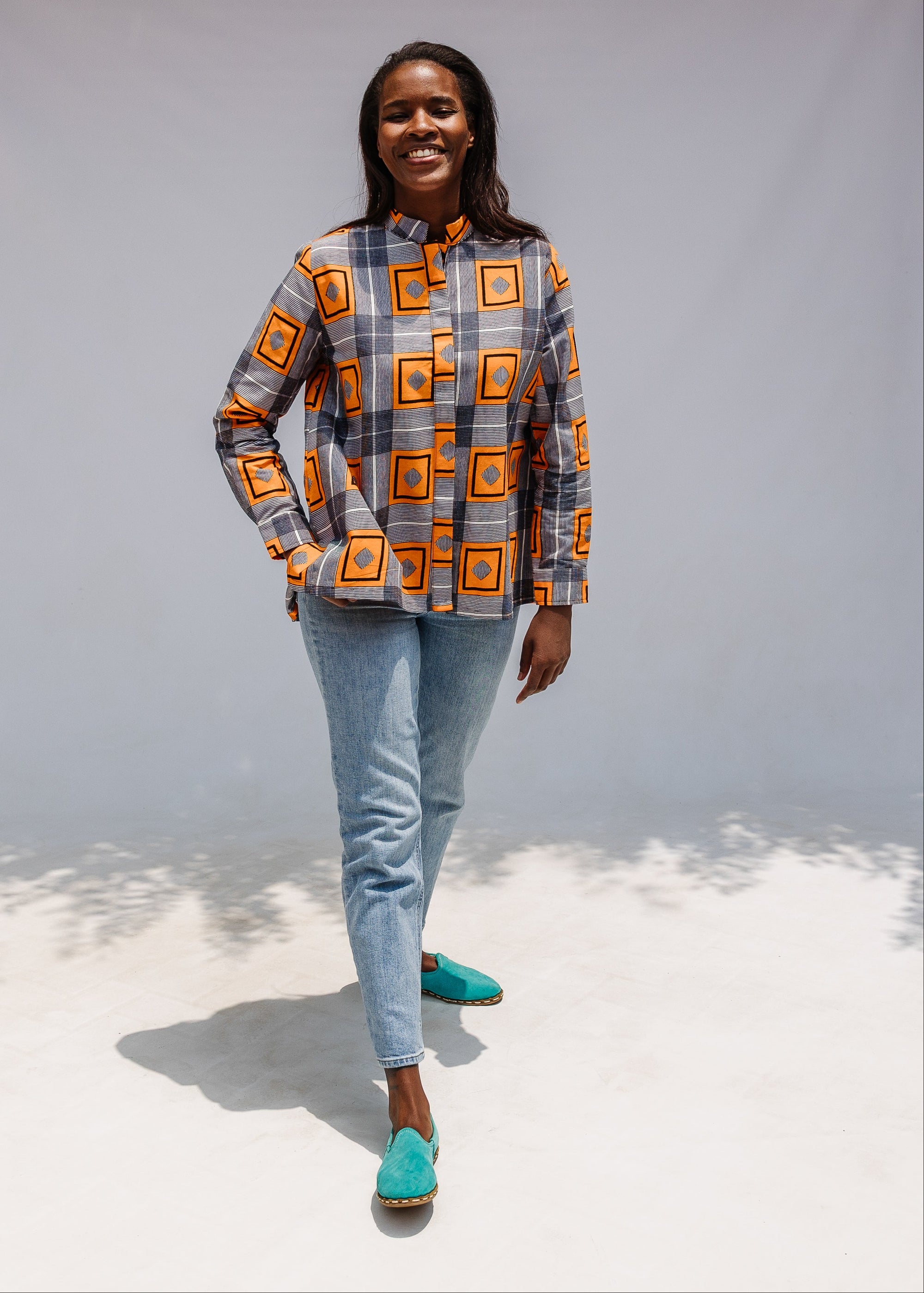 Model wearing orange, navy and white geometric print shirt.