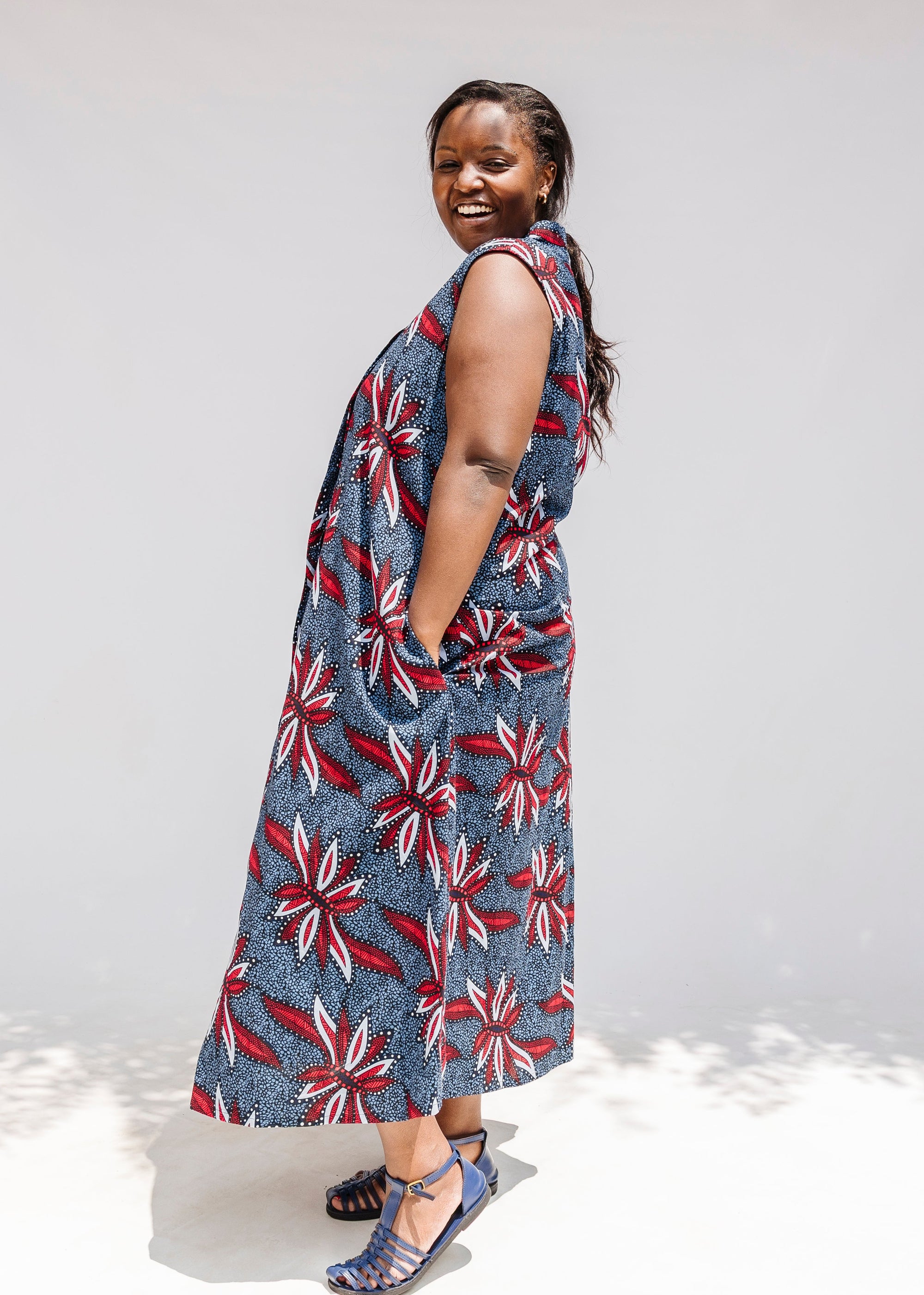 Model wearing grey, red and black dragonfly print dress.