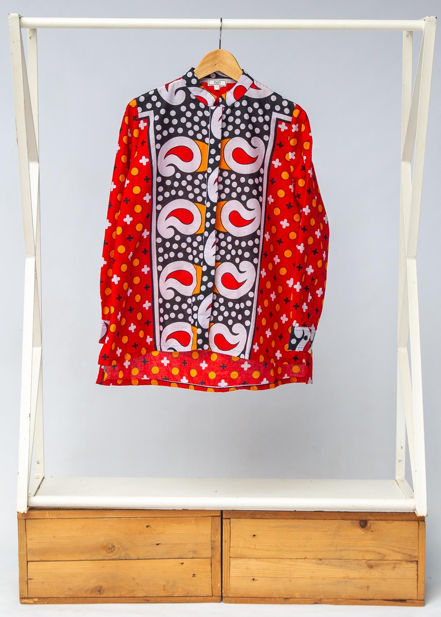 Display of red, white, black and orange mixed pattern long sleeved kanga shirt