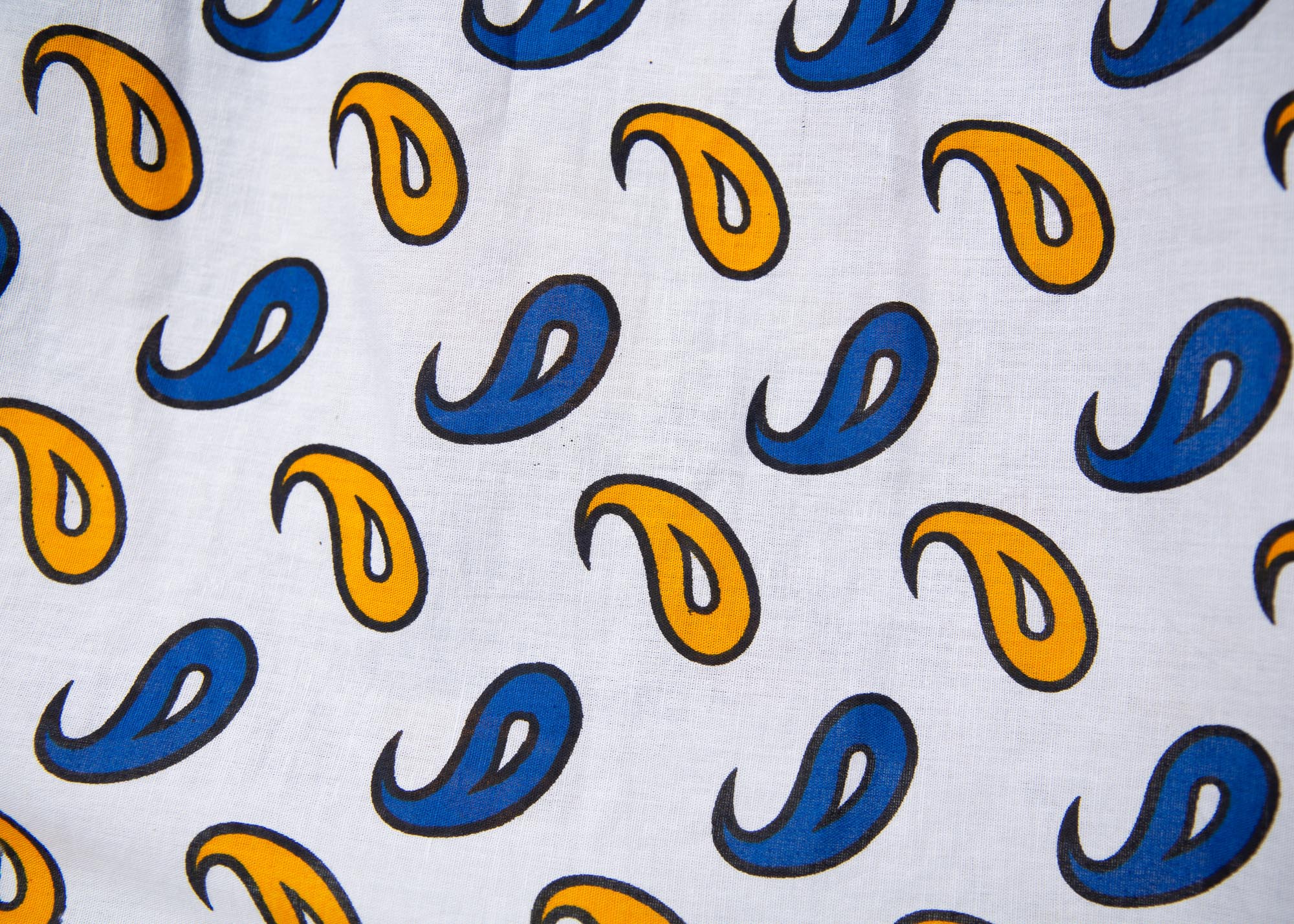 Close up display of white, blue, black and orange mixed pattern long sleeved kanga shirt