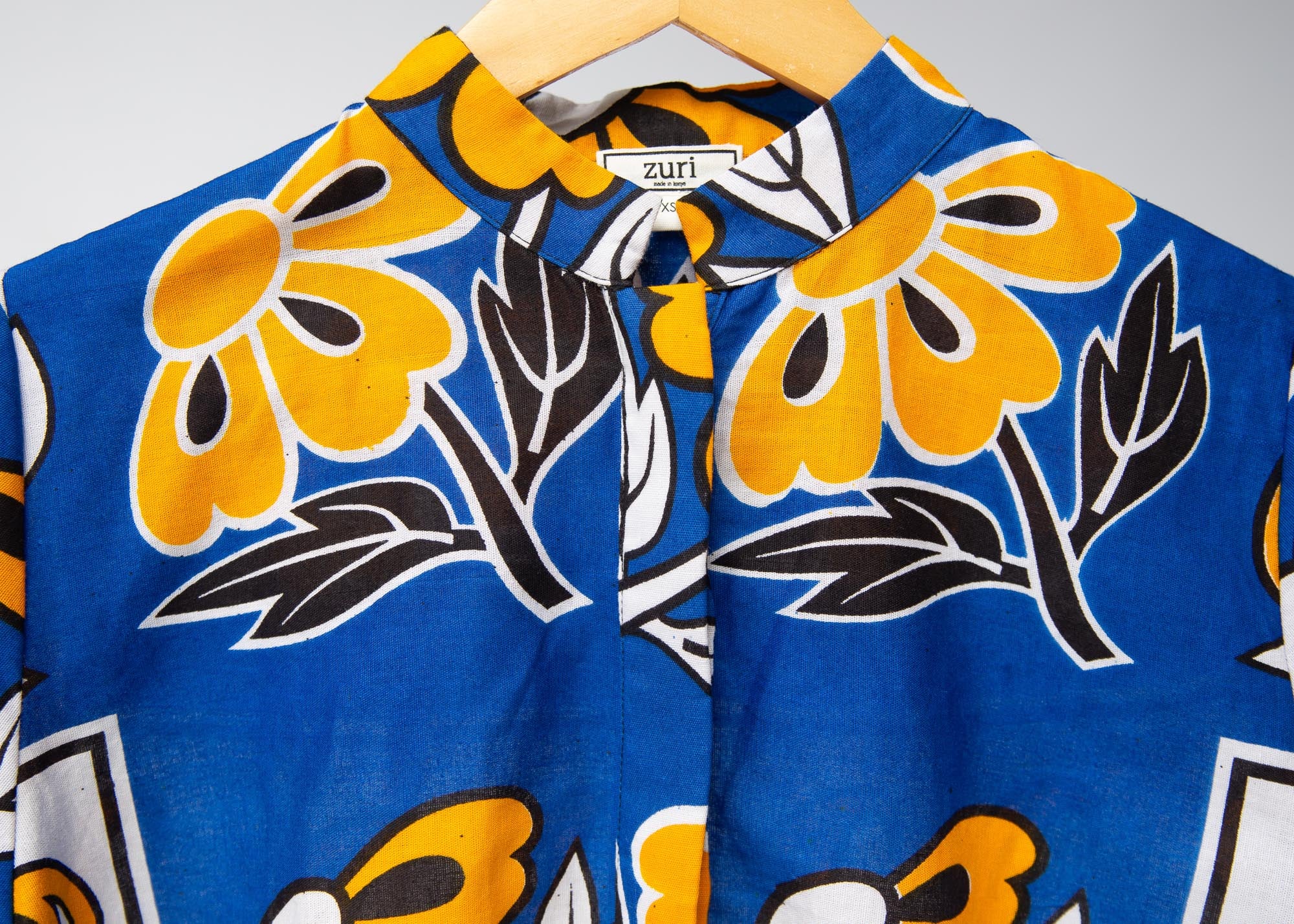 Display of white, blue, black and orange mixed pattern long sleeved kanga shirt