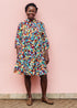 The model is wearing multi colored geometric print dress