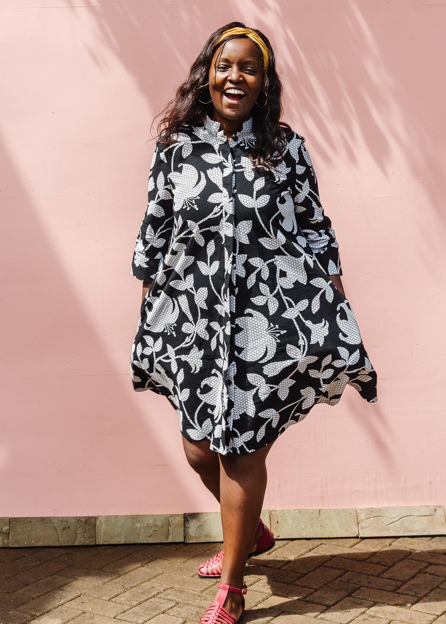 The model is wearing black dress with white and gray leaf print