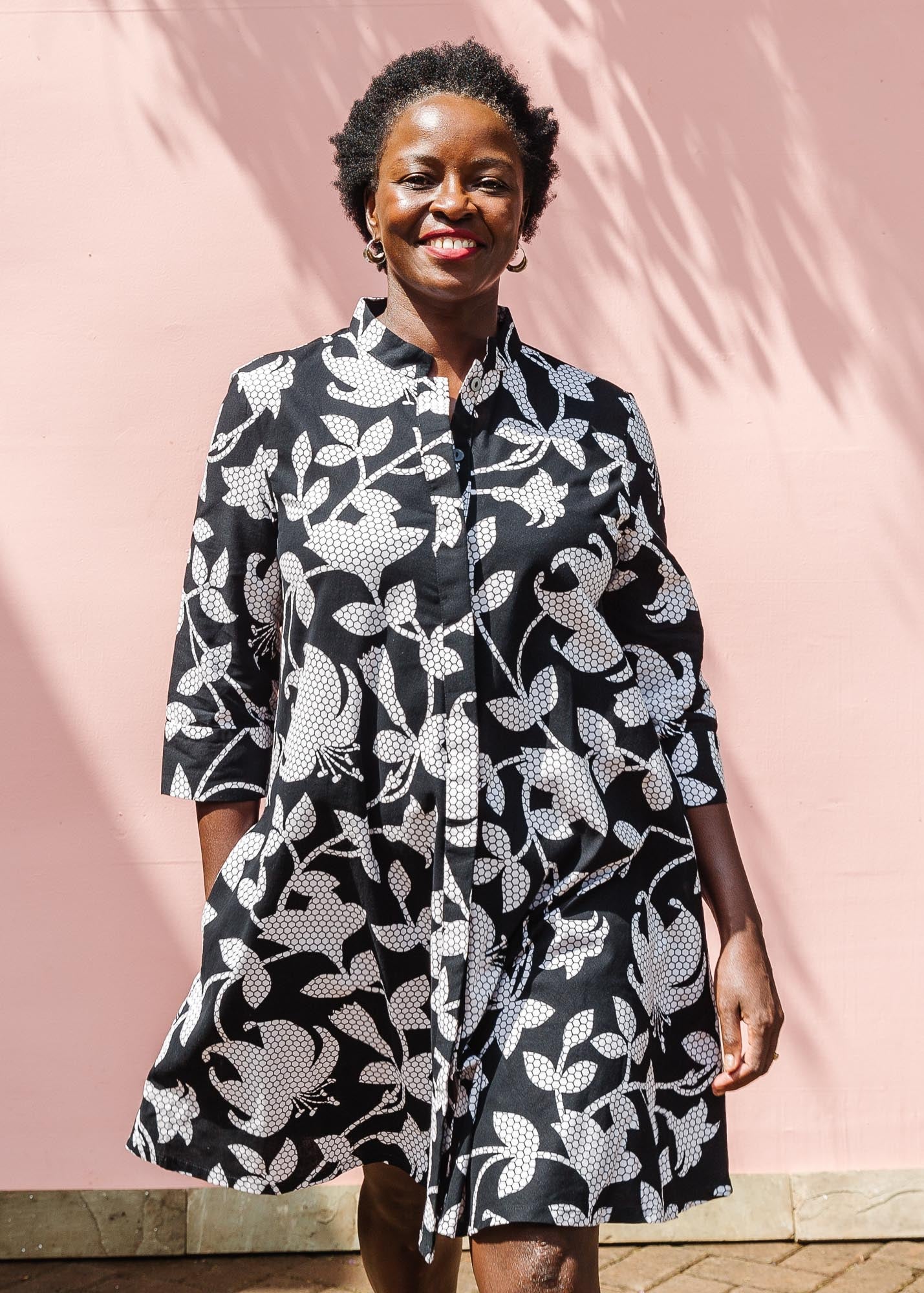 The model is wearing black dress with white and gray leaf print