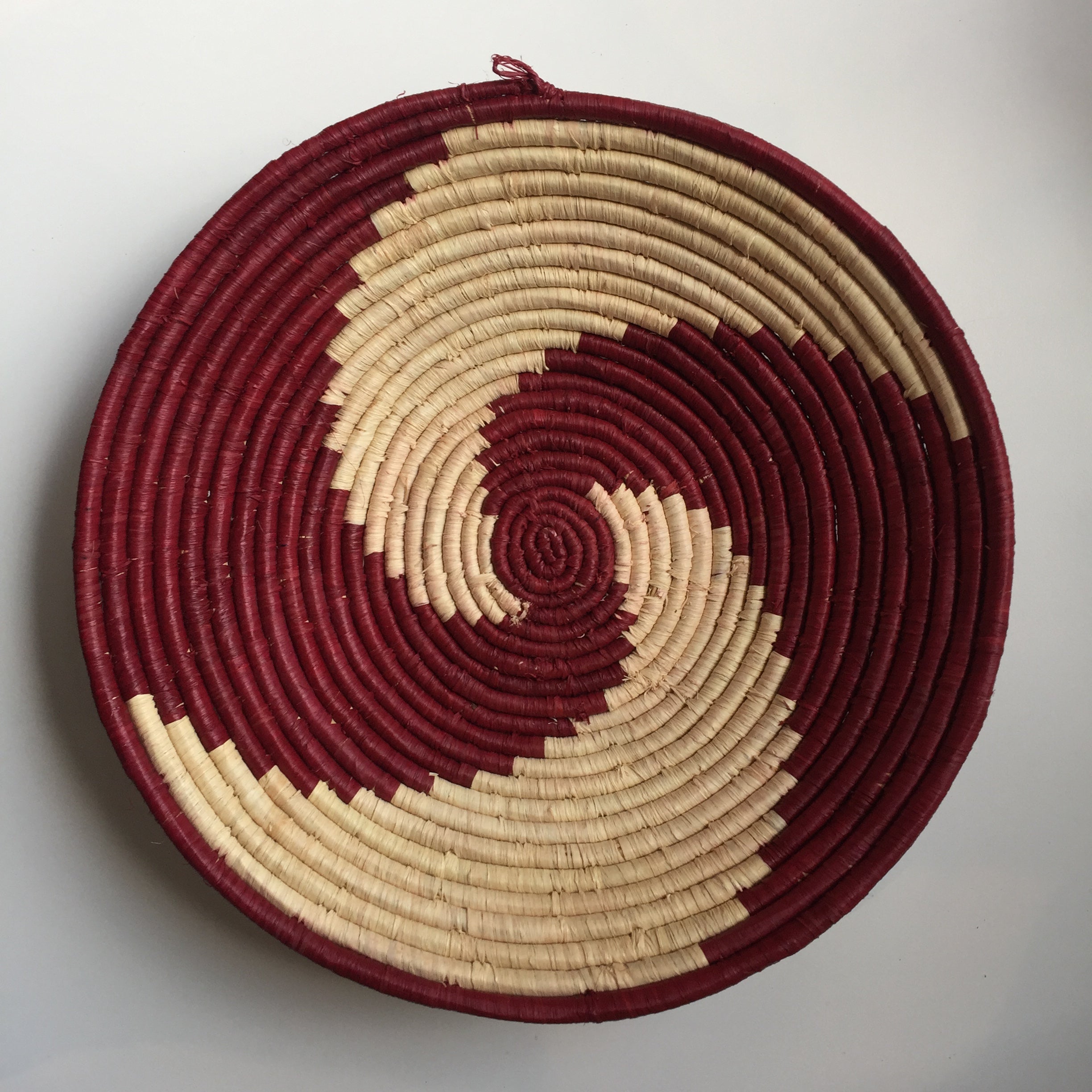 Burgundy and natural pinwheel design woven bowl