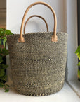 Black and white woven sisal basket with leather handle.