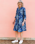 Model wearing blue paisley dress, paired with white sneakers.