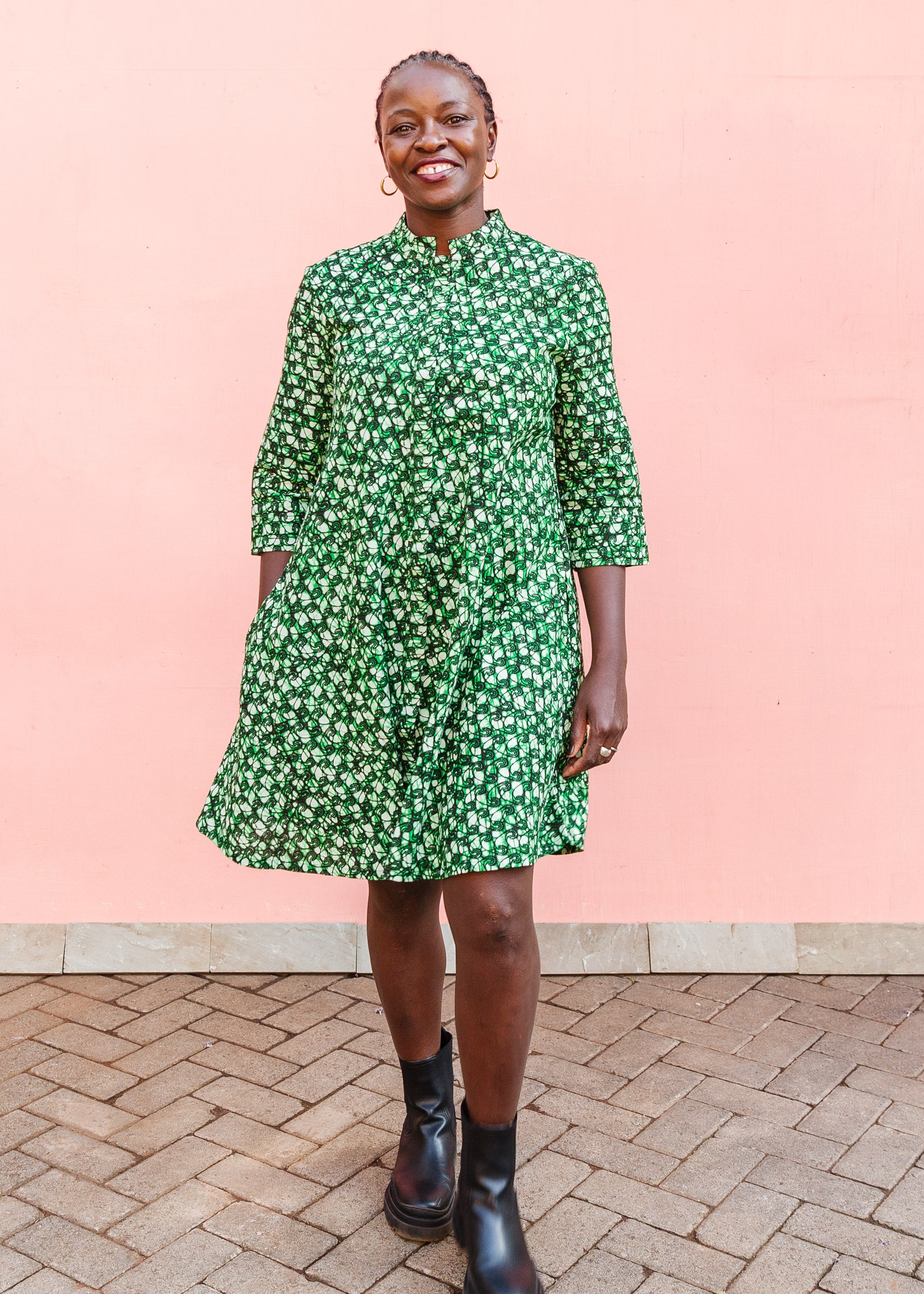 Model wearing green paisley print dress, paired with black boots.