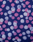 Close up display of purple dress with pink shaded polka dots, fabric.