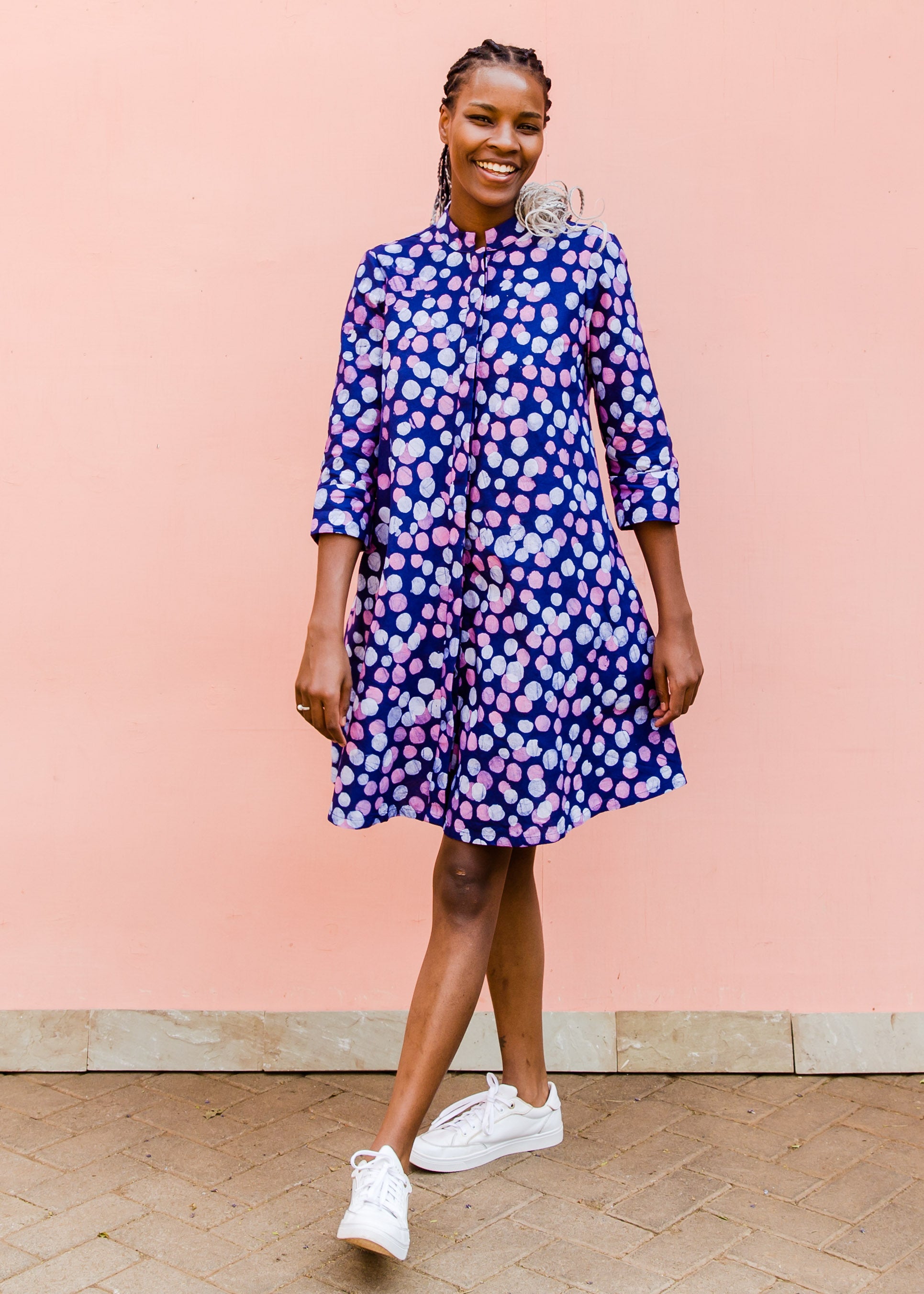 Model wearing purple dress with pink shaded polka dots.
