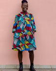 Model wearing rainbow dress with black boots.