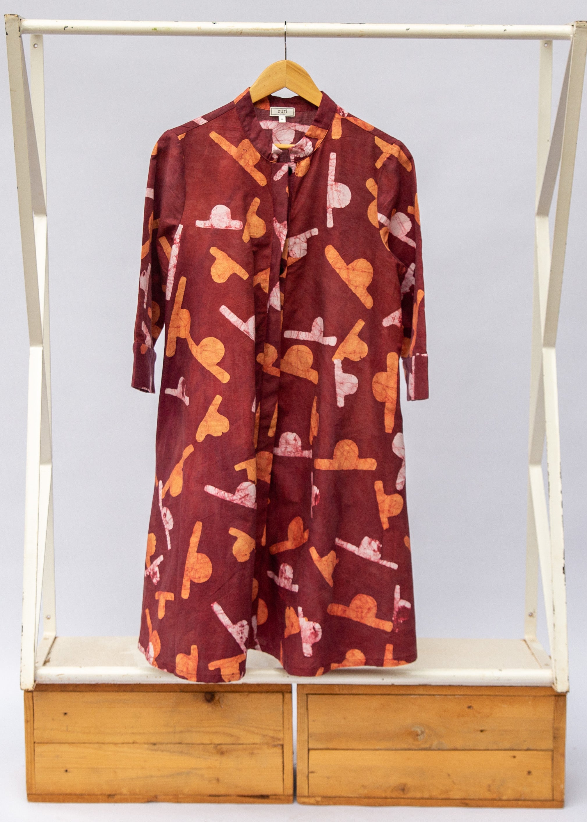Maroon dress with abstract white and orange shapes