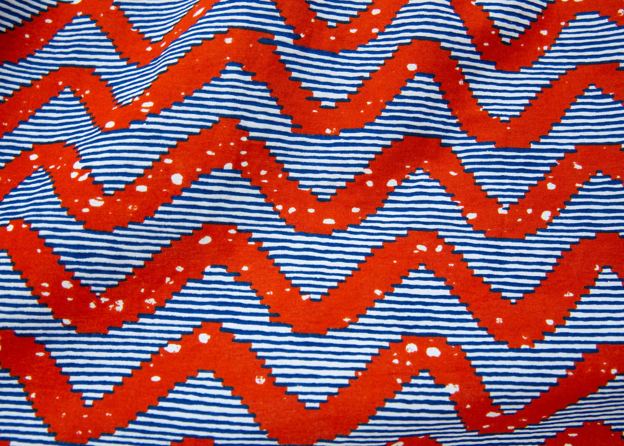 Close up display of blue and red zigzag print fabric.